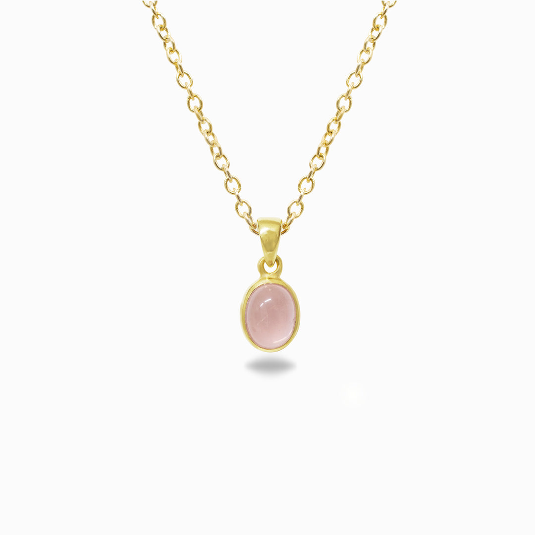 Gold necklace with a pink pendant on a white background
