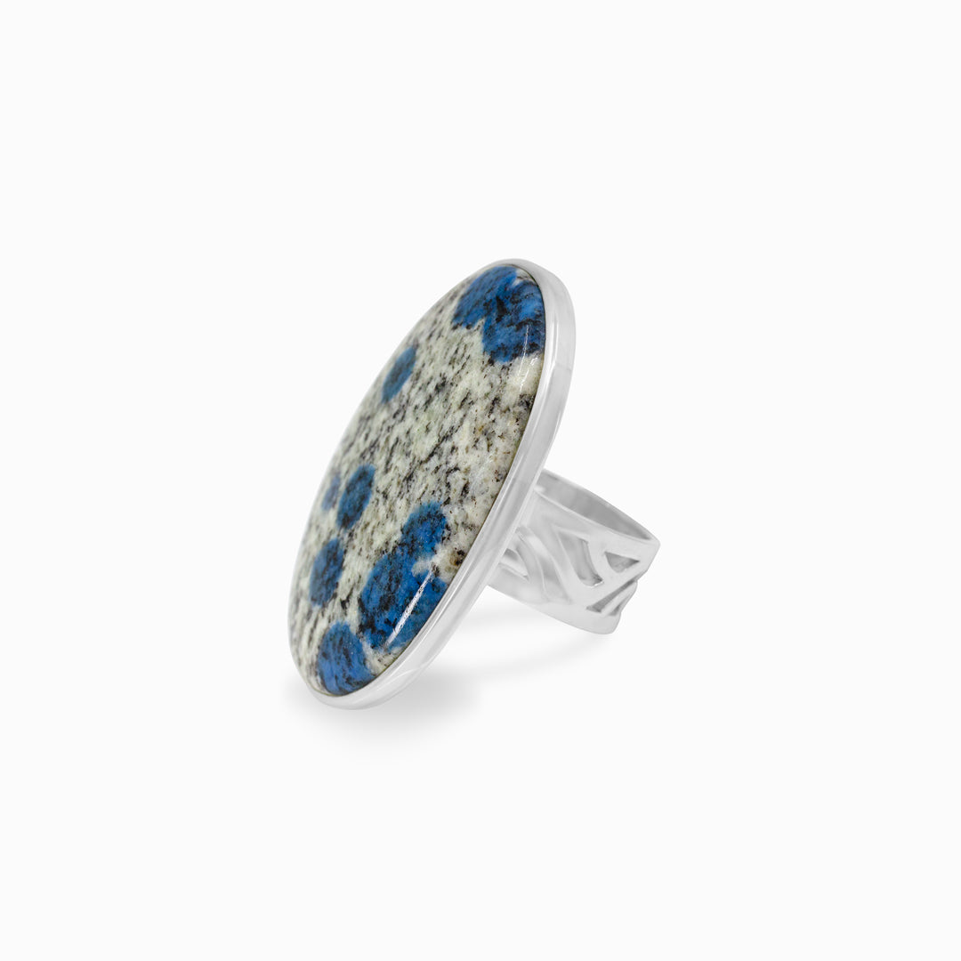 Silver ring with a gemstone with blue and white patterns on a white background
