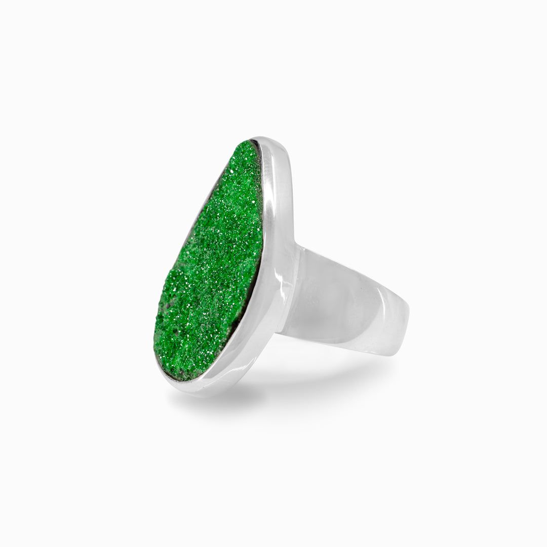 Silver ring with a green stone on a white background