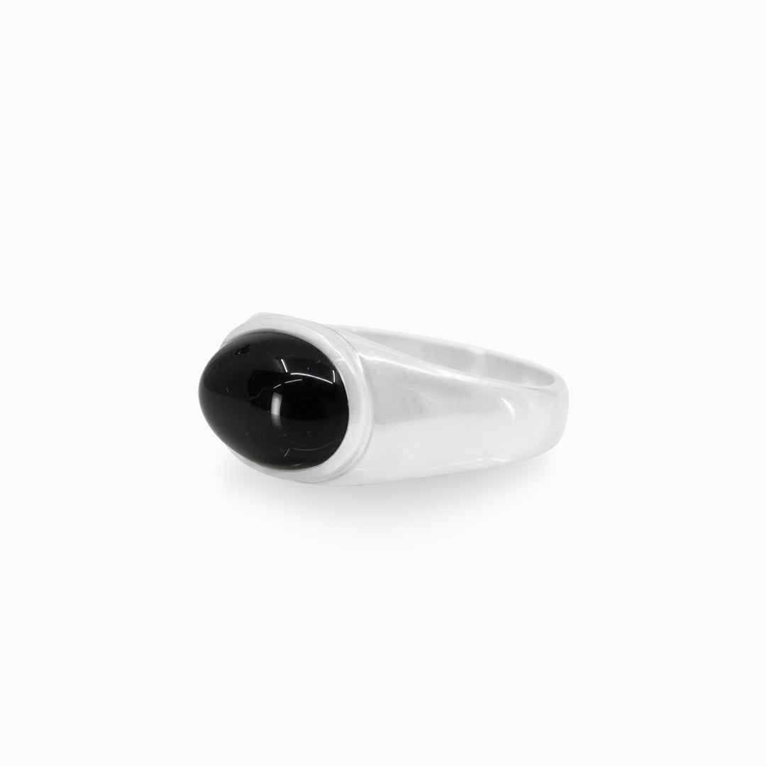 Silver ring with a black stone on a white background
