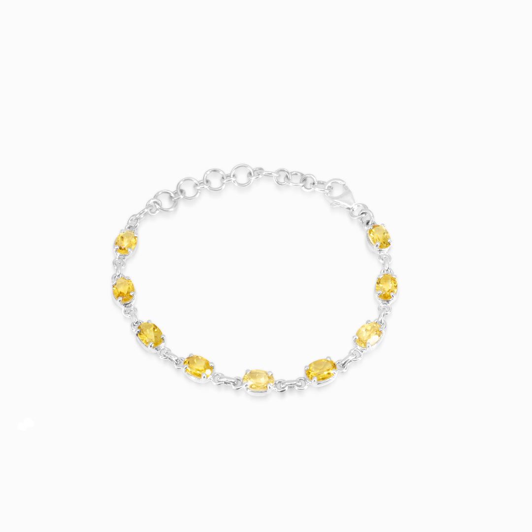 Silver bracelet with yellow gemstones on a white background