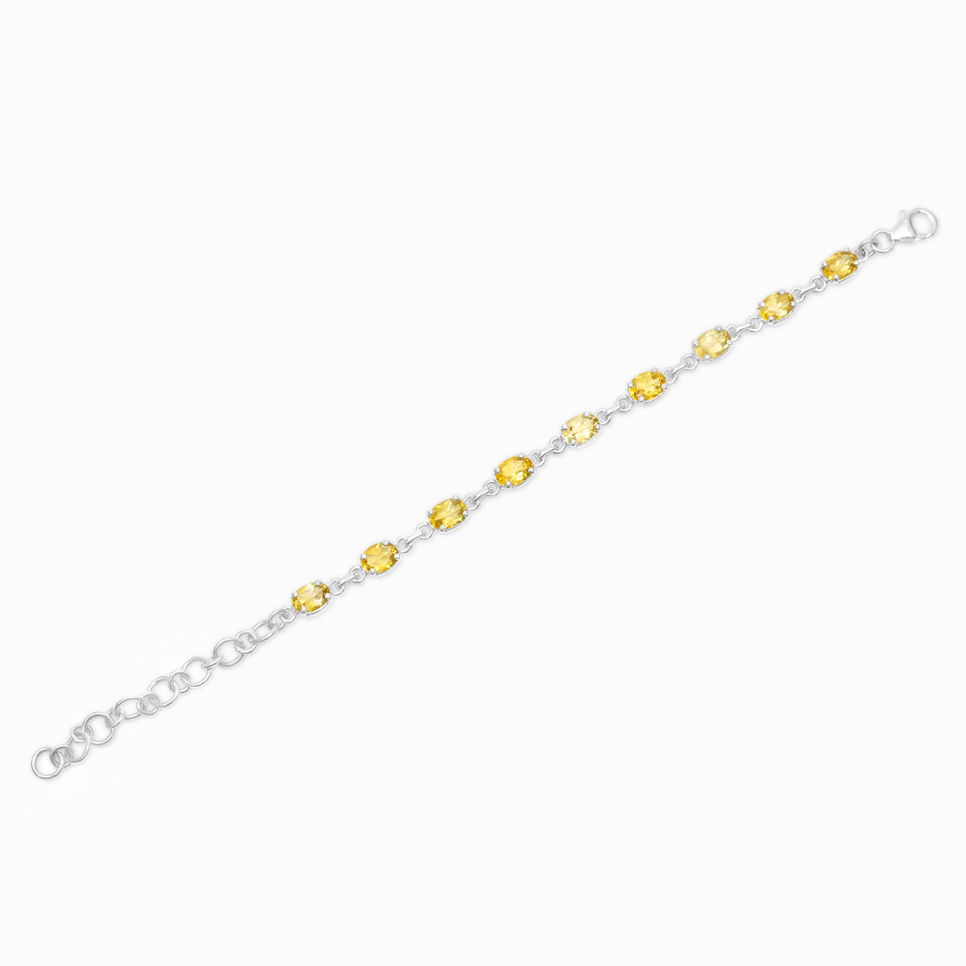 Silver bracelet with yellow gemstones on a white background
