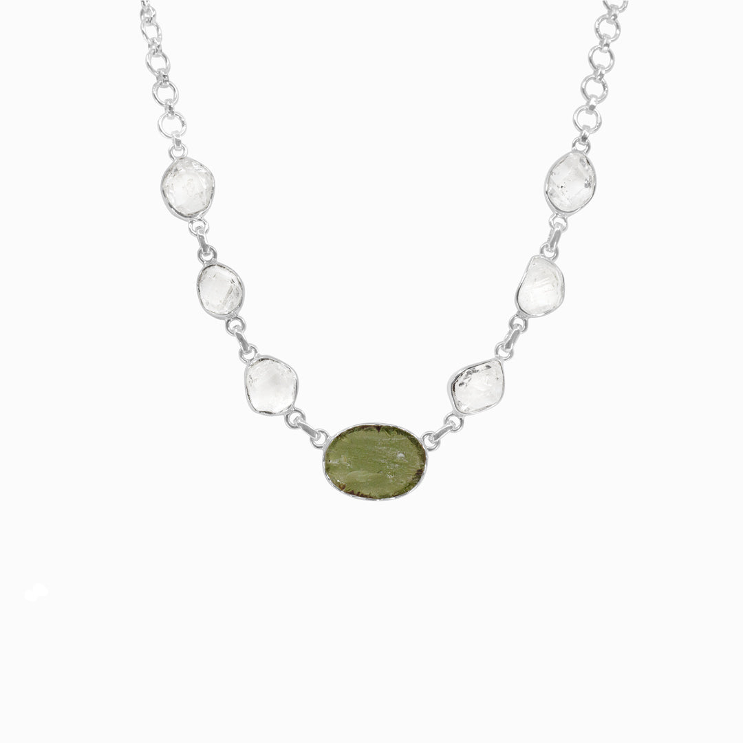 Silver necklace with green and clear gemstones on a white background