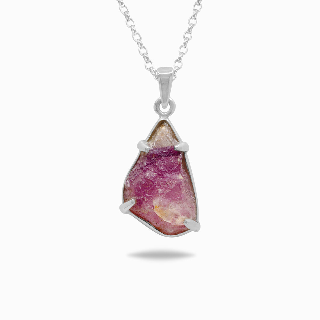 Silver necklace with a pink stone on a white background
