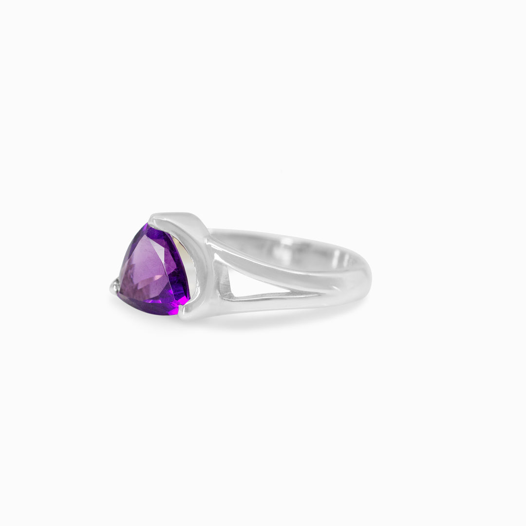 Silver ring with a purple gemstone on a white background