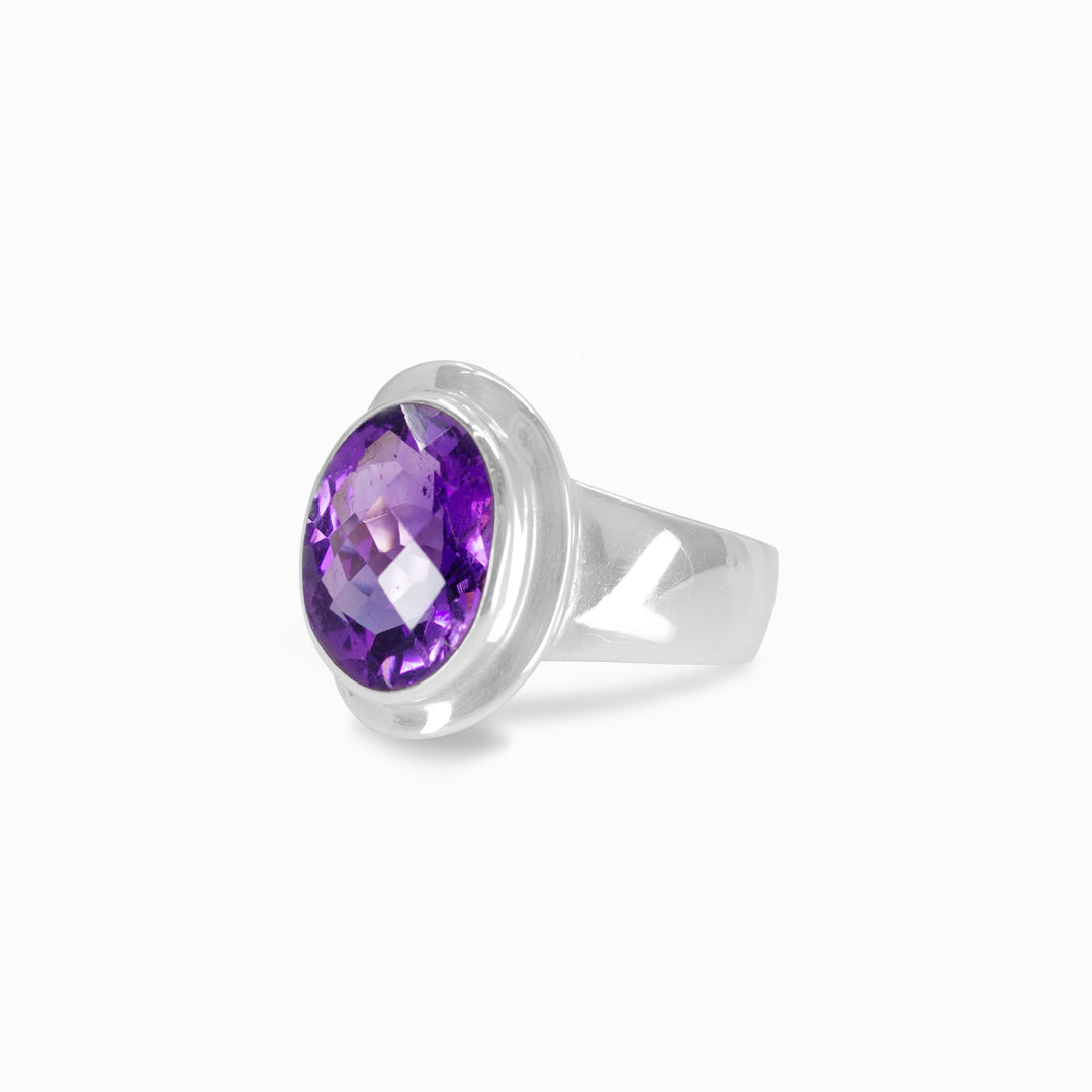 Silver ring with a purple gemstone on a white background