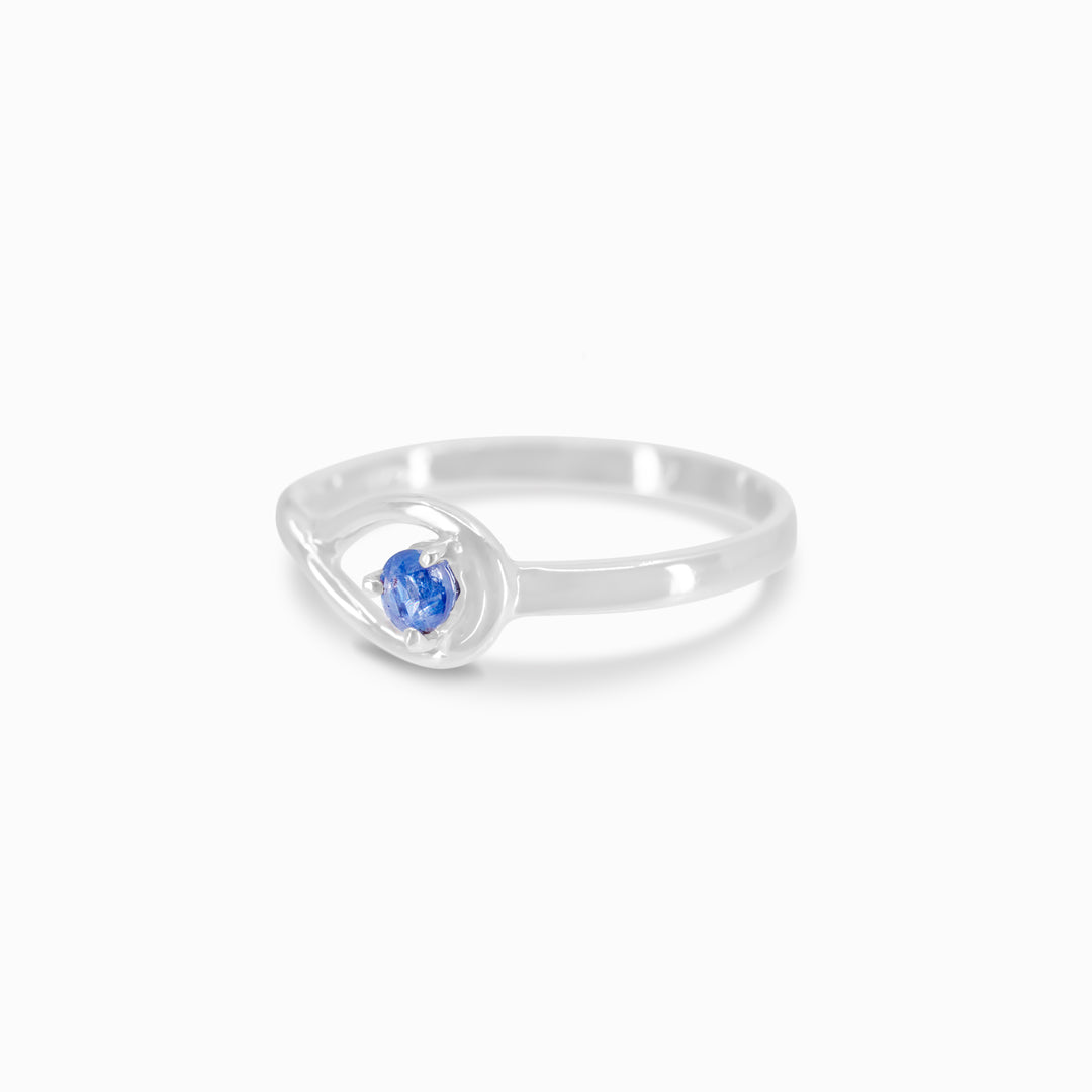 Silver ring featuring a blue gemstone, set against a white background.