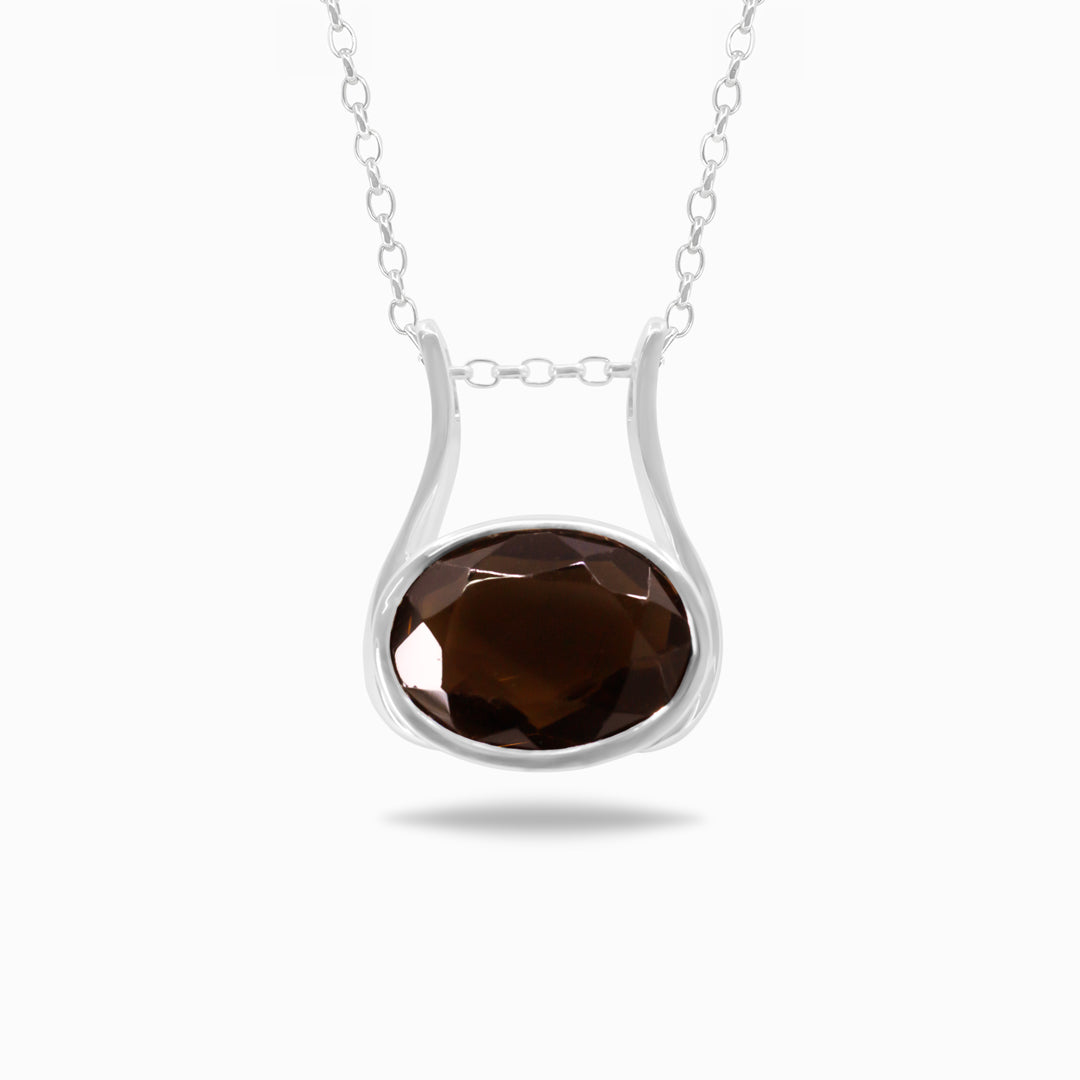Silver necklace featuring a pendant with a brown gemstone, set against a white background