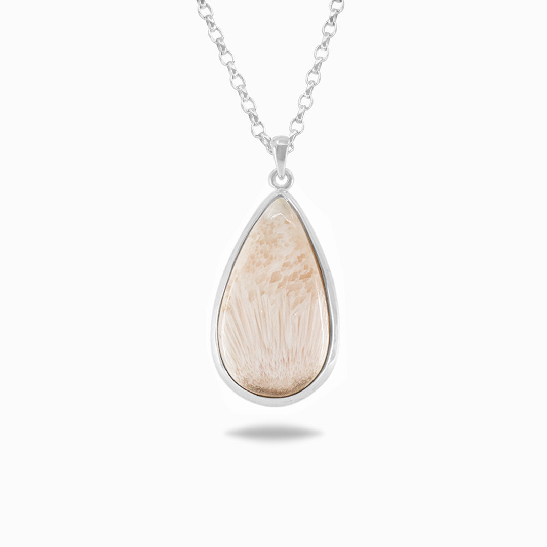 Silver necklace with a light pink gemstone on a white background.