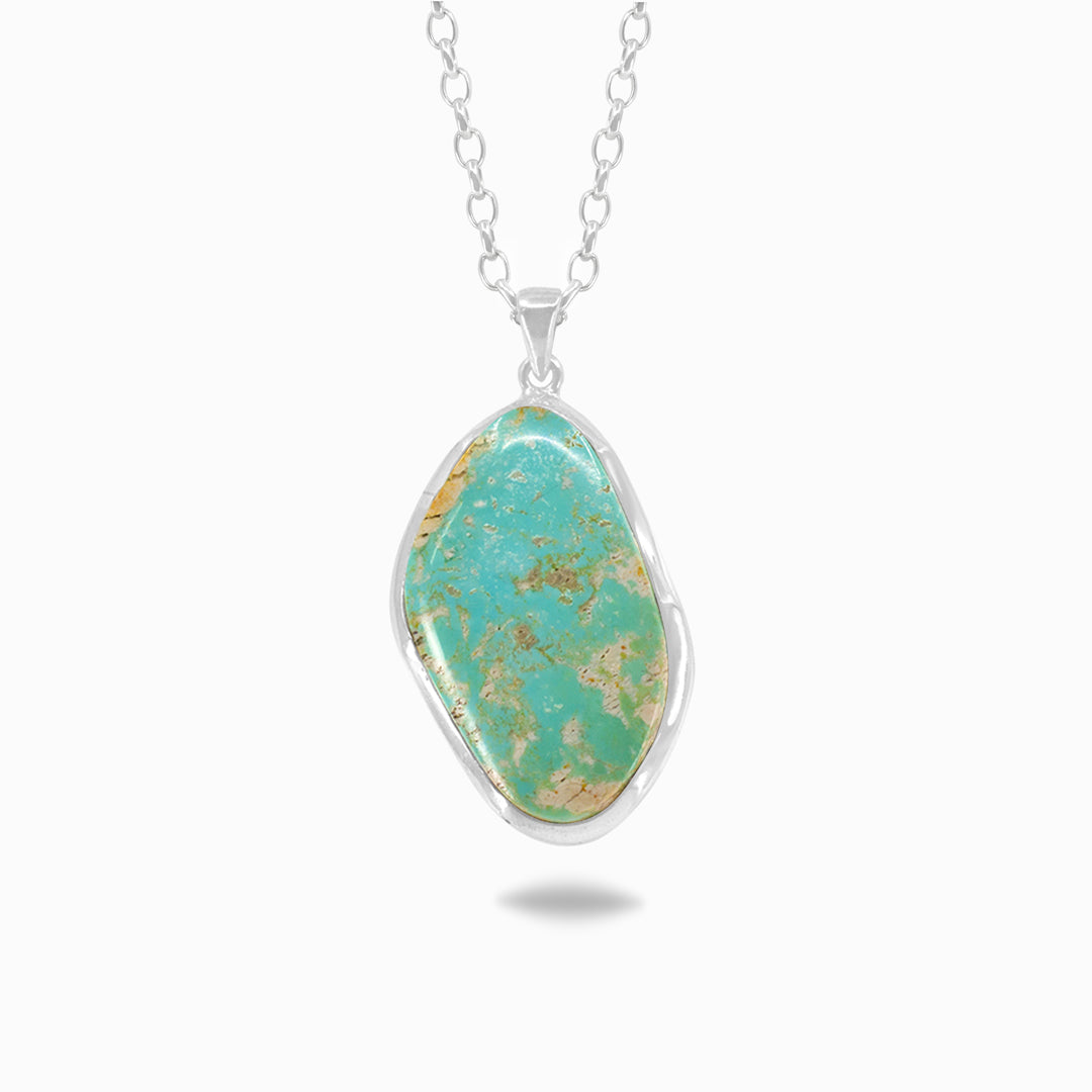 Turquoise stone pendant on a silver chain against a white background