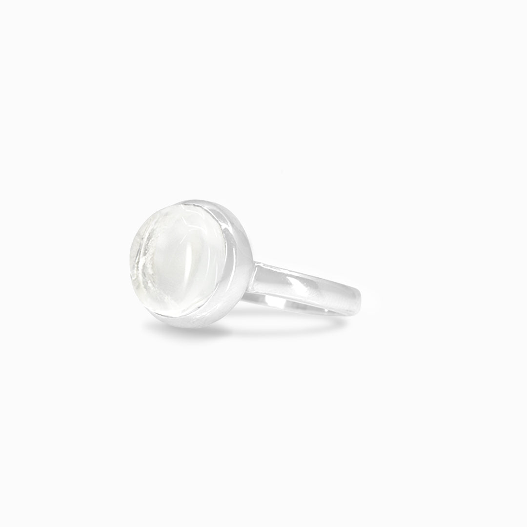 Silver ring with a clear stone on a white background.
