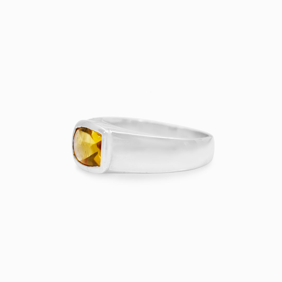 Silver ring with a yellow gemstone on a white background