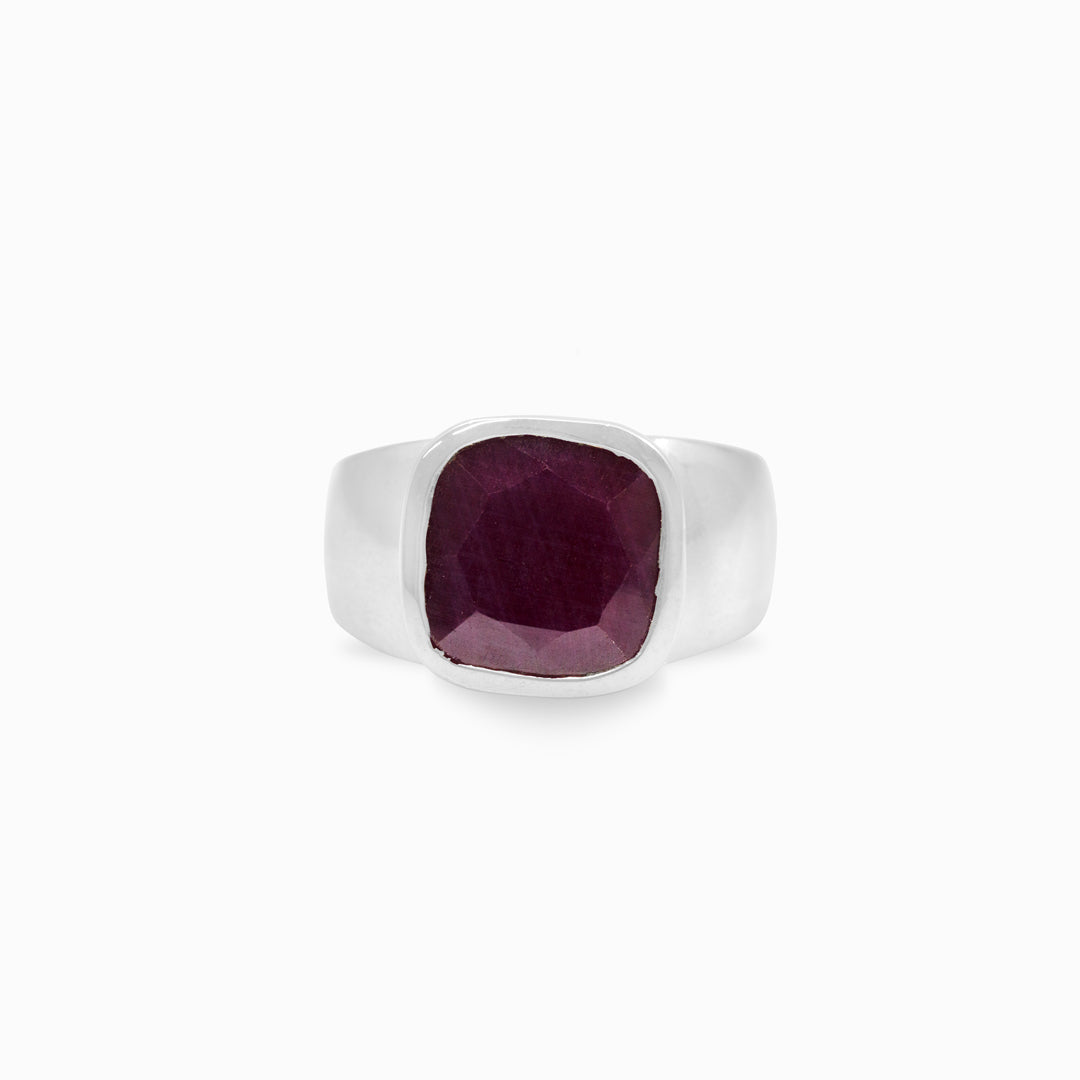 Silver ring with a crimson gemstone on a white background