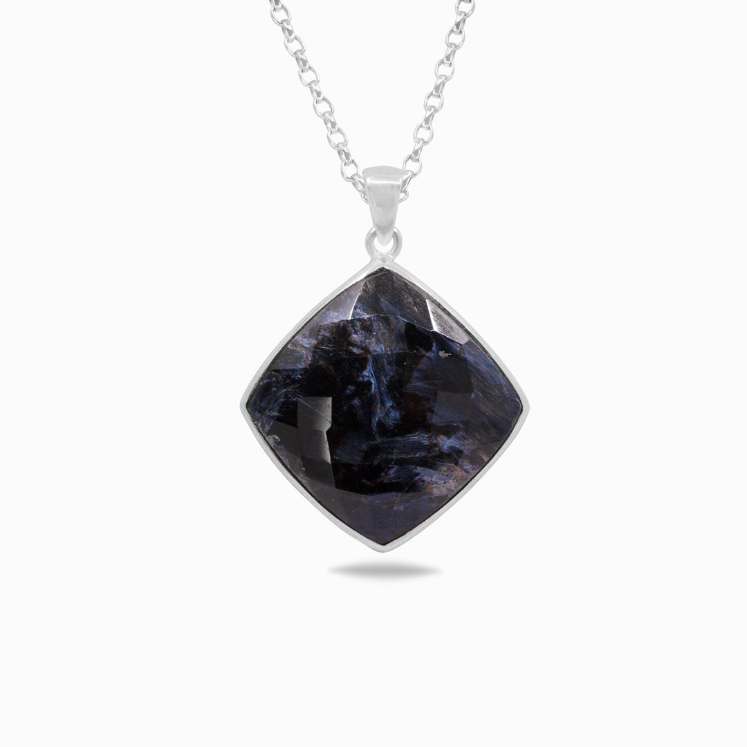 Silver necklace with a dark blue stone on a white background