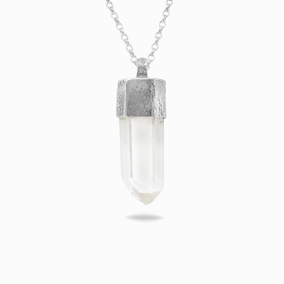 Silver necklace with a clear stone on a white background.