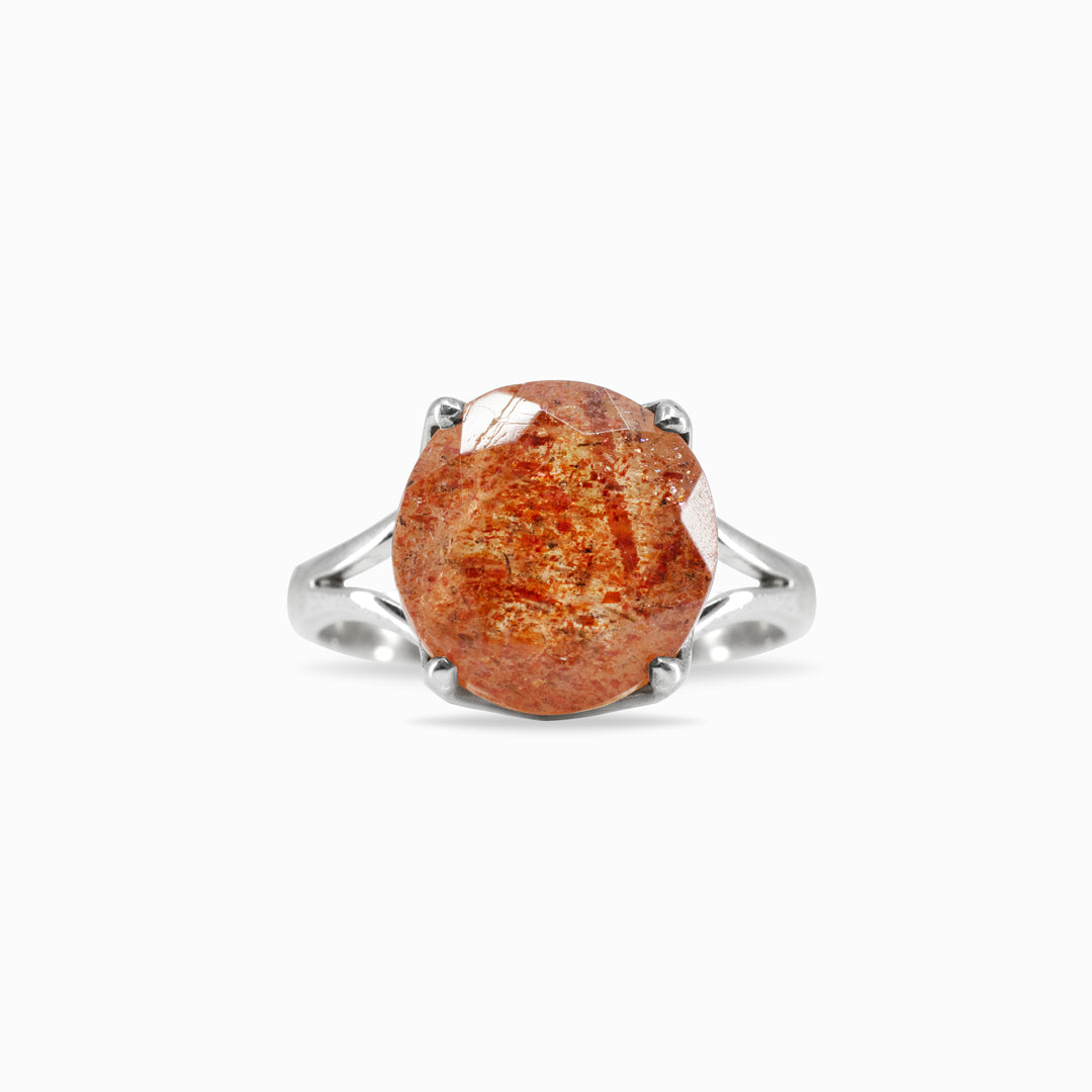 Silver ring with an orange gemstone on a white background