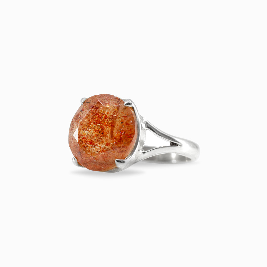 Silver ring with an orange gemstone on a white background