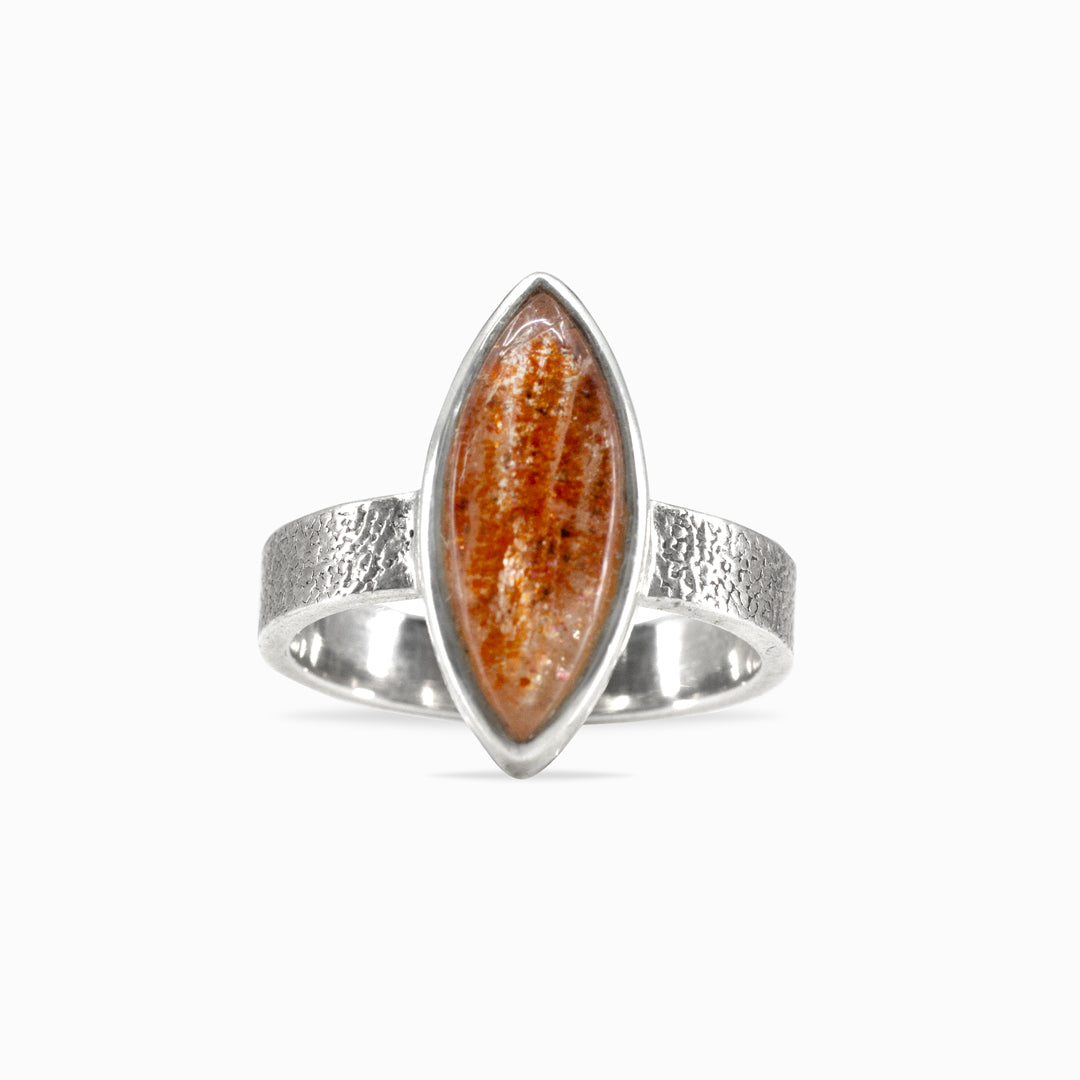 Silver ring with a marquise-shaped orange gemstone on a white background
