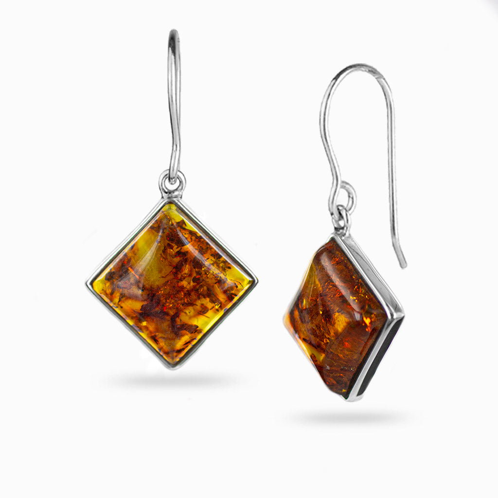 yellow with orangey flame like detail. square shape cabochon cut, bezel set hooks. hooked from a corner.